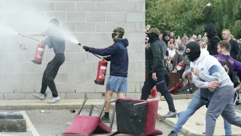 PA Media Rioters seen charging and spraying fire extinguishers