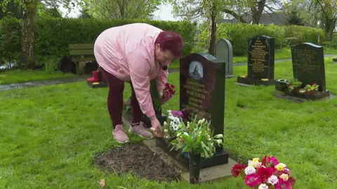 Anita Jewitt-Holder tends to her parents grave