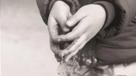 University of Sunderland Sand slipping through the hands of Hendrix. The black and white image is part of his mother's final project.