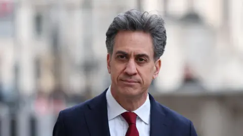 Reuters Head and shoulders image of Ed Miliband. He is wearing a blue jacket, white shirt and dark red tie.