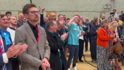 Reform UK members celebrate during the local election count for Plymouth City Council.
