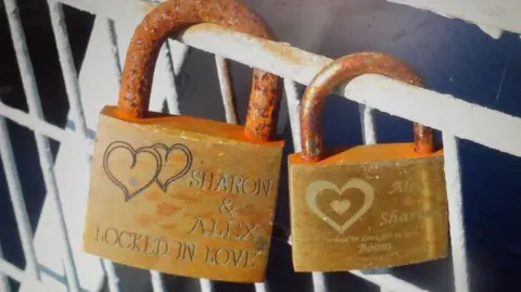 John Lawson-Reay Two padlocks affixed to a the railings of a footbridge