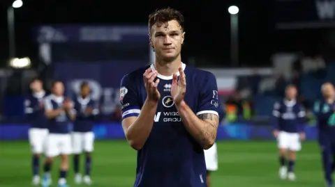 Millwall captain Jake Cooper applauds the fans, looking dejected after they were beaten by Hull City