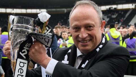 Derby County owner David Clowes with a trophy claimed for winning promotion from League One as runners-up