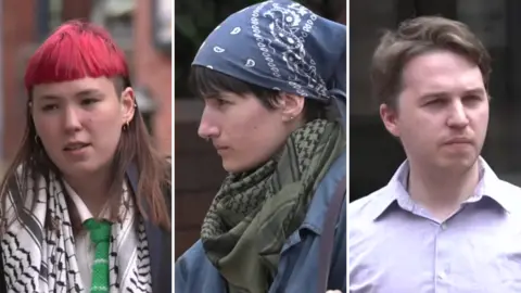 Three people - a woman with brown hair died red at the top and a black and white scarf, a woman with black hair and a blue head scarf and a man with brown hair and a pale shirt