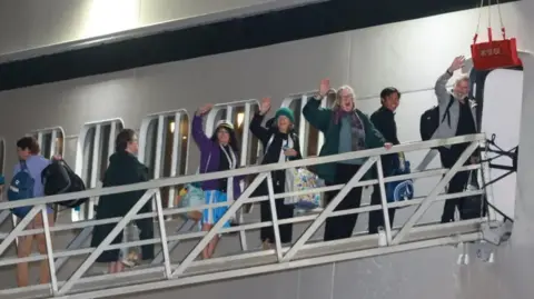 PA Media People waving as they board a cruise ship