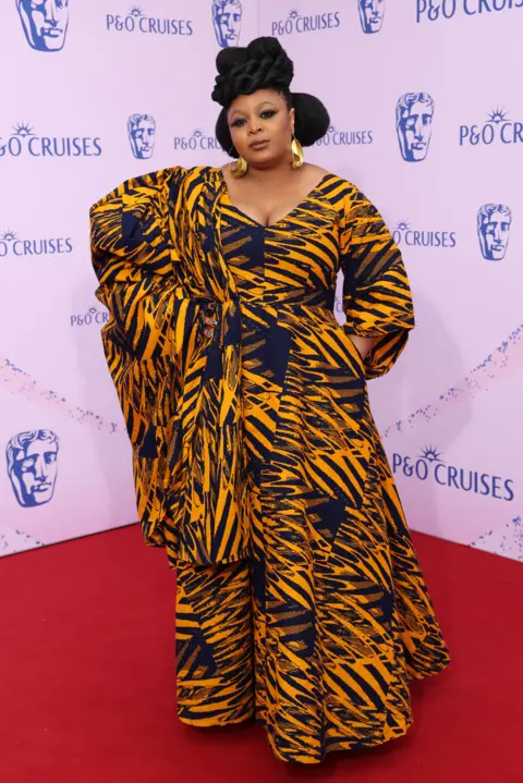 Getty Images Gbemisola Ikumelo in a patterned orange and black dress