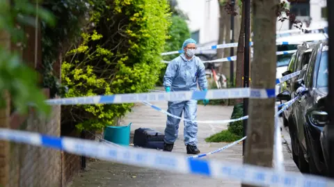 Police investigate the scene of a fire in Kentish Town