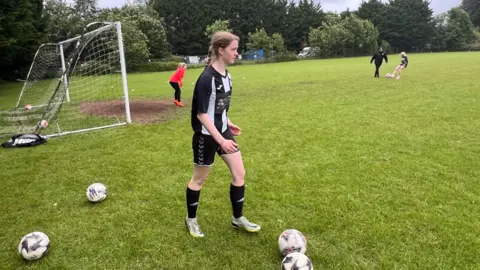 BBC A woman in a black football kit at an Odd Down FC training session in Bath