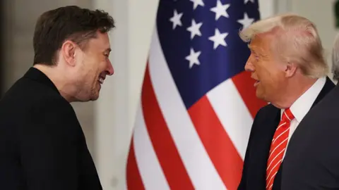 Elon Musk and Donald Trump in front of an American flag.