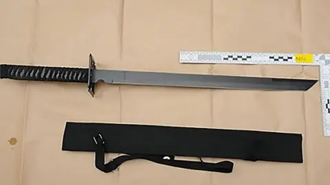 A straight-edged ninja sword next to a sheath