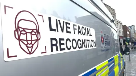 Nine police vans lined up with cameras attached to the top