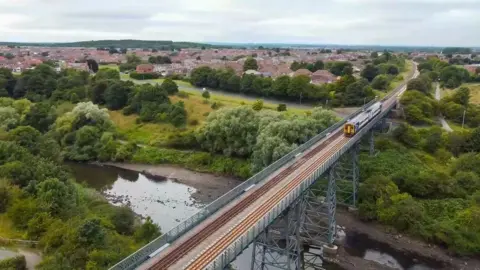 Northern Train crossing a bridge over a river