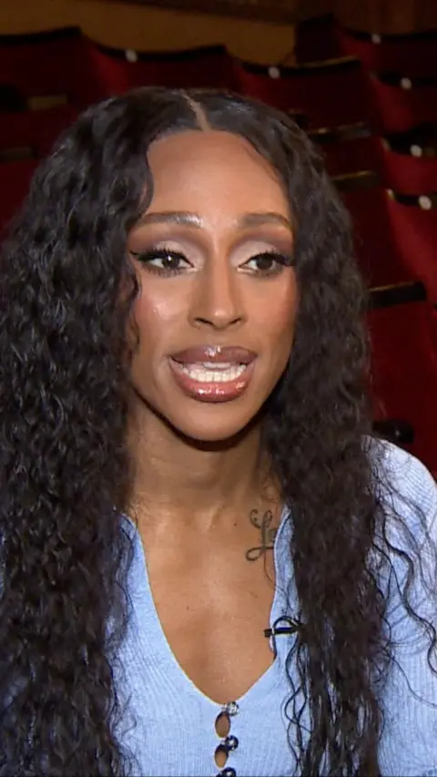 Alexandra Burke wearing a blue top sat in a theatre 