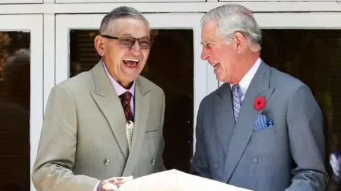 AFP Then Prince Charles and King Tuheitia laugh as they exchange a gift 