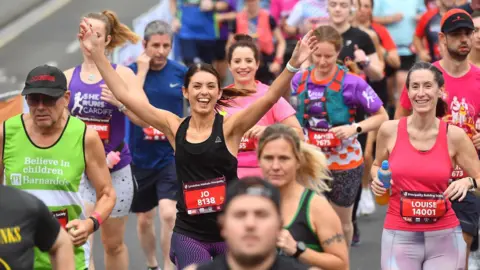 Run 4 Wales Runners in multi-coloured vests and leggings smile at the camera as they compete in the 2023 half marathon