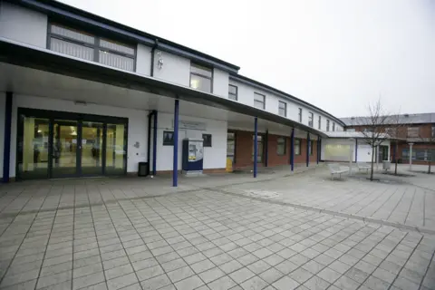 Coventry and Warwickshire Partnership NHS Trust Exterior of the Caludon Centre in Coventry, which has a white facade, and blue metal poles along the front of the building.