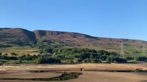 Scorched grass surrounds a reservoir in Derbyshire in 2022.