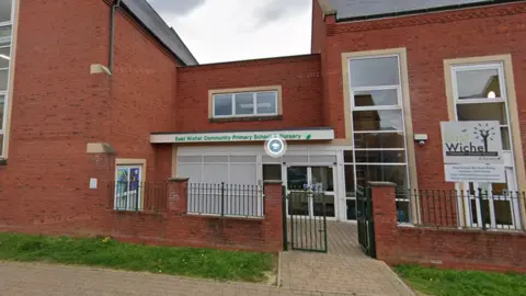 The front of a school with the words "East Wichel Community Primary School & Nursery" over the front door.
