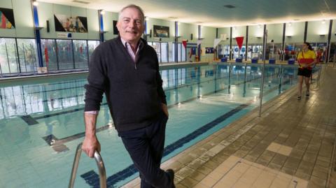 A councillor standing by a pool 