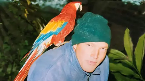 Tom Hart Dyke Tom Hart Dyke in 2000 wearing a green beanie hat and looking to camera with a large parrot on his shoulder