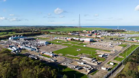 PA Media A wider view from the air of the Bacton Gas Terminal - it's a large industrial site with the North Sea in the background.