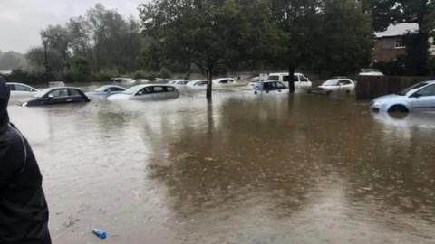 A car park showing cars submerged in floodwater