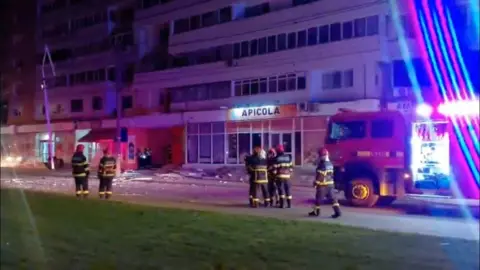 Reuters Firefighters work near a building, which was hit by a drone in Galati