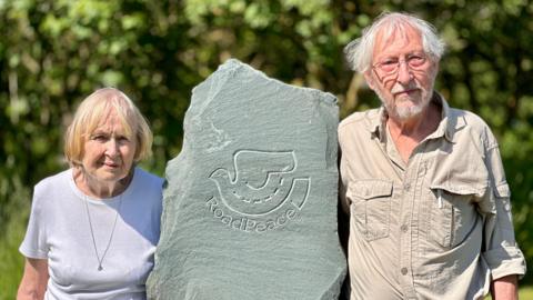 Patsy and Robbin Suffield standing either side of a RoadPeace memorial stone