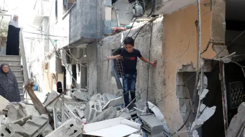 Alaa Badarneh A boy stands on top of rubble from buildings damaged during a two-day Israeli army operation in Tulkarm, in the occupied West Bank (30 August 2024)