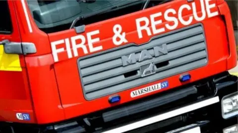 Close-up of a red fire appliance with the words Fore and Rescue on the front of it