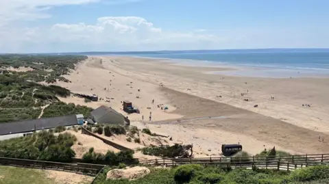 BBC Saunton Sands beach with buildings in the foreground and the entrance to the Taw Estuary in the distance