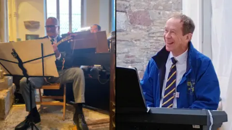 Supplied The picture is split in two. On the left is Bill Spill sat in a chair playing ukelele. He's smiling while looking at sheet music, wearing a shirt and tie and suit jacket with grey trousers. He appears to be in a church-like building. On the right is Alan Hemsley who is playing keyboard. He is looking to the left and smiling. He is wearing a shirt and tie and a blue coat. He is back by a grey brick wall.