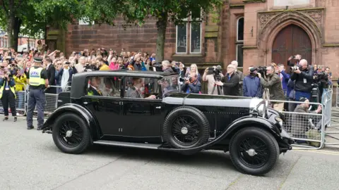 PA Media Olivia Henson arrives in a vintage car for her wedding to Hugh Grosvenor, Duke of Westminster at Chester Cathedral