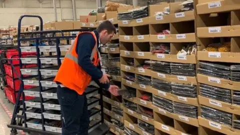 BBC/Marc Gaier A warehouse worker sorts through stock at Kammac’s Wavertree site in Liverpool