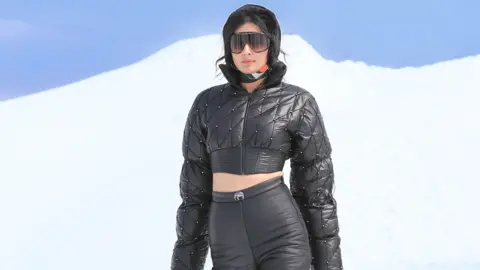 Equipe Shivan & Narresh Um modelo mostra uma roupa em Gulmarg contra um cenário de neve