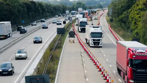 Kent County Council An image of Operation Brock in a previous year, which shows large trucks being directed down the opposite carriageway by red and wine traffic cones.