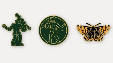National Trust Three pin badges on a white background. On the left is a green badge depicting the Cerne Abbas giant from behind - the naked hill figure is holding a club in his right hand and his left arm is outstretched. His round buttocks have a line around the top implying that they are shiny. The centre badge is round with the original naked Cerne giant in the centre. The pin on the right is of a yellow and black patterned butterfly.