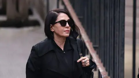 Sadie Frost wearing sunglasses and a black jacket before entering court