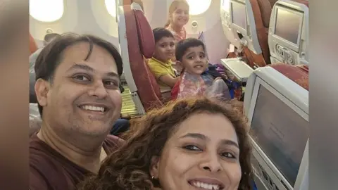 Supplied Dr Prateek Joshi (L) takes a selfie with his wife and three children on the plane