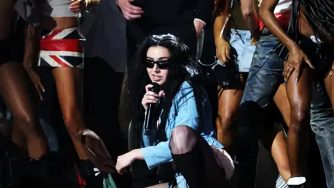 Getty Images Charli XCX performing on stage with her dancers at the Grammys