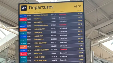 A departures board which shows around a dozen flights including three to London Heathrow which are marked as "Cancelled"