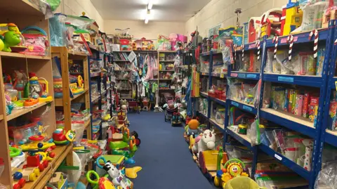 A room with shelves on each side stacked high with colorful childrens toys