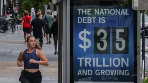 Getty Images An electronic billboard displaying the current US National debt per person and as a nation at 35 Trillion dollars on  09 August, 2024 in Washington, DC