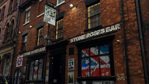 Stone Roses Bar A view of the Stone Roses Bar from the outside. A British flag is draped in the window.
