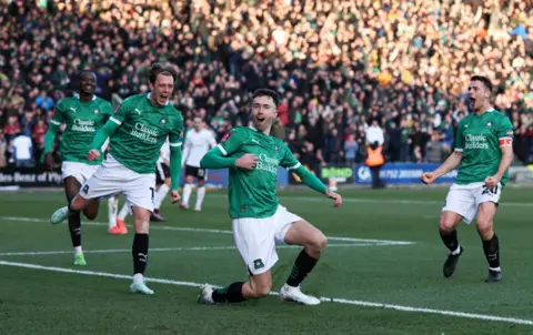 David Klein/Reuters Plymouth Argyle Ryan Hardie merayakan mencetak gol ketika rekan setimnya Callum Wright dan Adam Randell bergerak ke arahnya