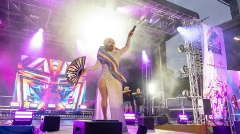 Drag act on stage at Southampton Pride - the stage it lit purple.