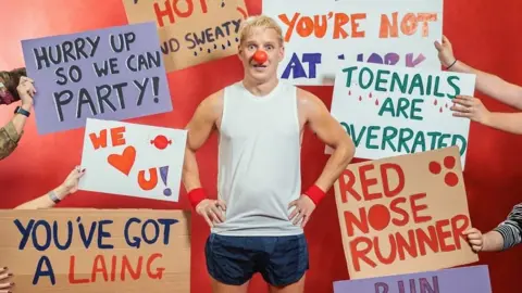 BBC/Comic Relief /Latoya Fits Picture of Jamie Laing surrounded by various signs