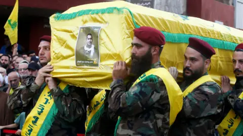 Reuters Hezbollah members transportation  the coffin, draped successful  yellow, of Hassan Youssef Abdel Sater who was killed connected  Friday successful  an Israeli onslaught   connected  Beirut's confederate  suburbs