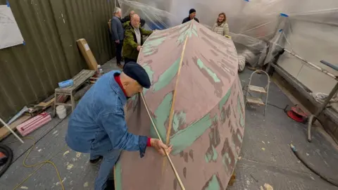 Coastal Forces Heritage Trust Volunteers around the sculpture take measurements.
